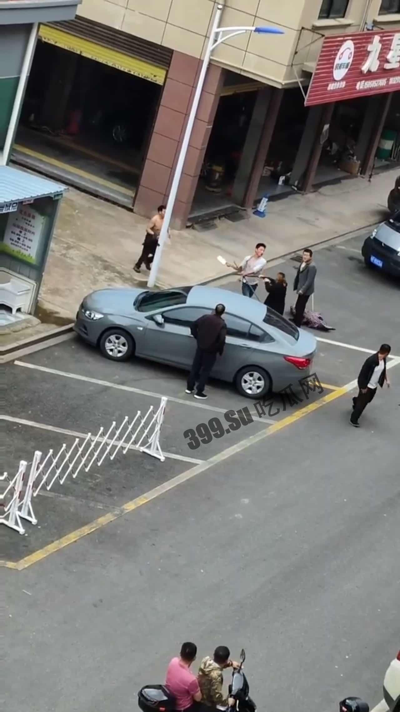 5月7日，浙江金华，男子拿菜刀沿街疯狂追砍一男一女，最后被女子扑倒在地制服，被砍者人没事，砍人男子已抓获-1